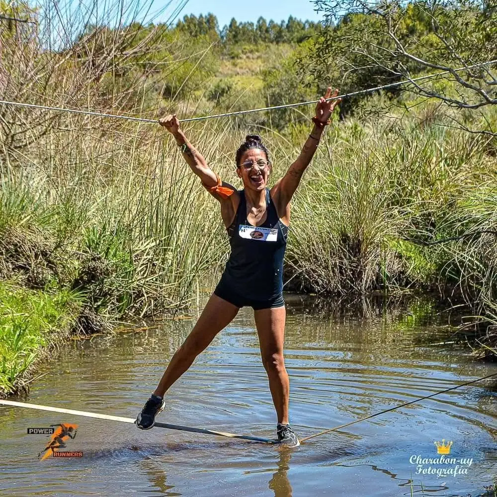 Participante festejando con los brazos abiertos tras cruzar el agua