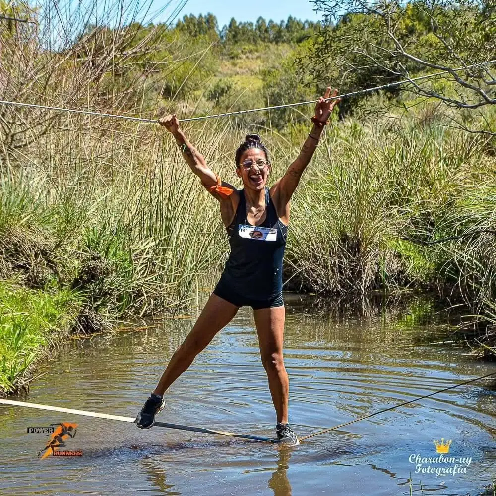 Participante festejando con los brazos abiertos tras cruzar el agua