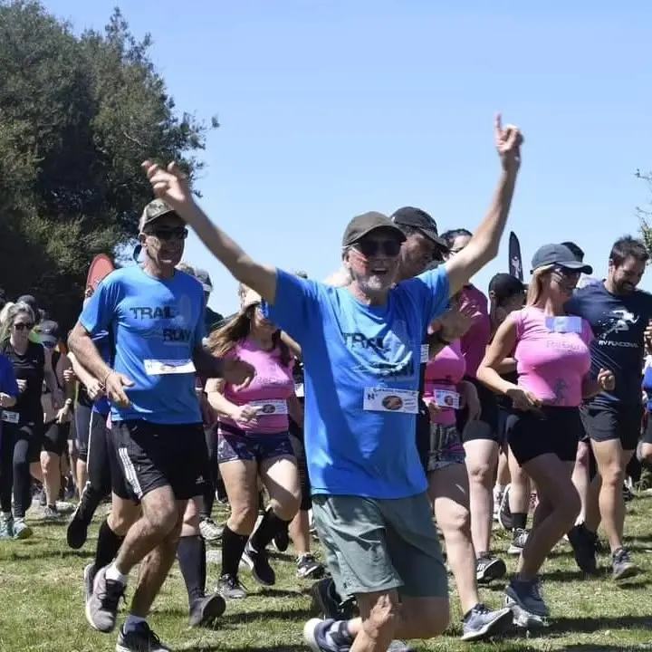 Grupo de participantes largando con los brazos en alto